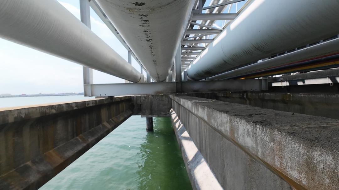 Pipe rack inspected from beneath at a jetty